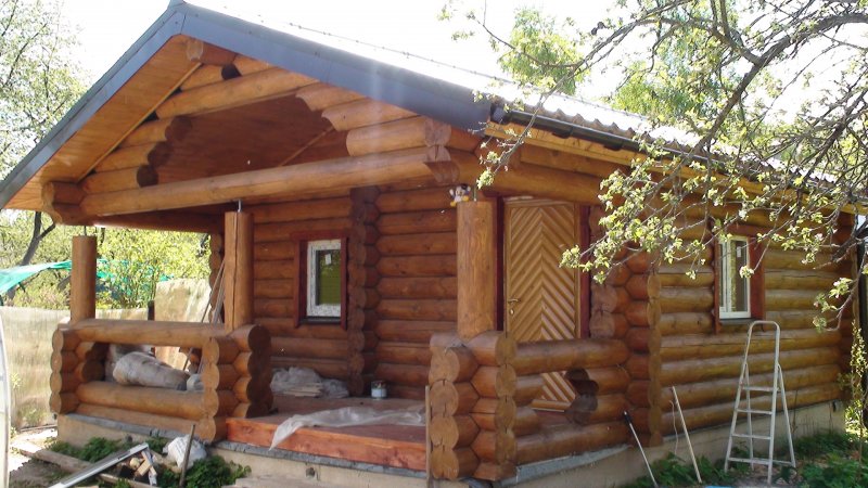 Баня из бревна с беседкой под одной крышей