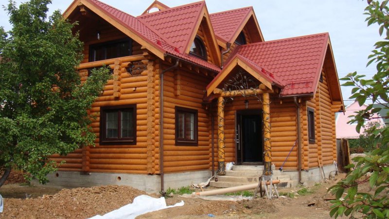 Дом из оцилиндрованного бревна с красной крышей