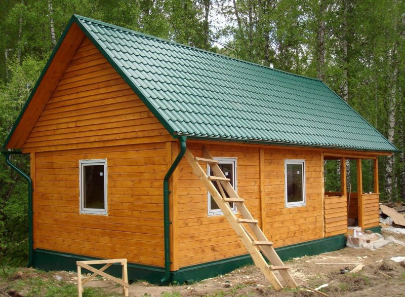 Деревянный дом с зеленой крышей