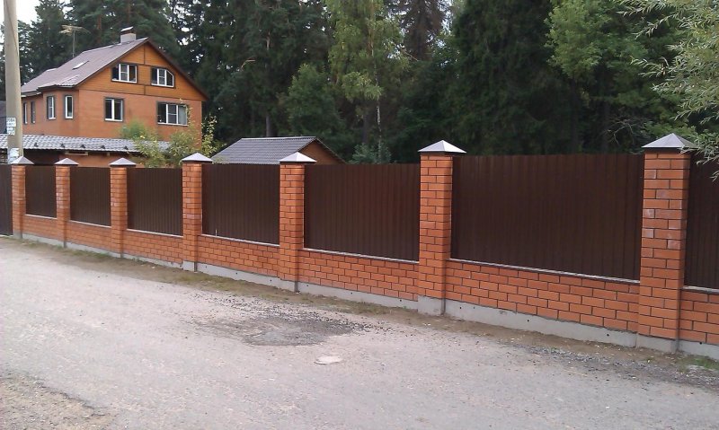 Забор с кирпичными столбами на уклоне