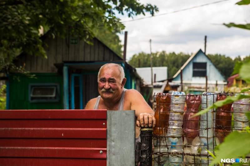 Мужик пластиковыми бутылями на даче