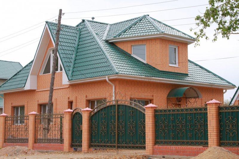 Дом из красного кирпича с зеленой крышей
