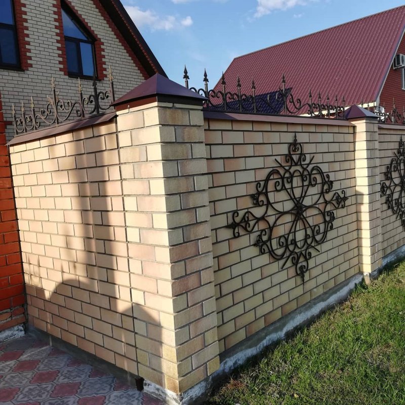 Забор из желтого кирпича с ковкой
