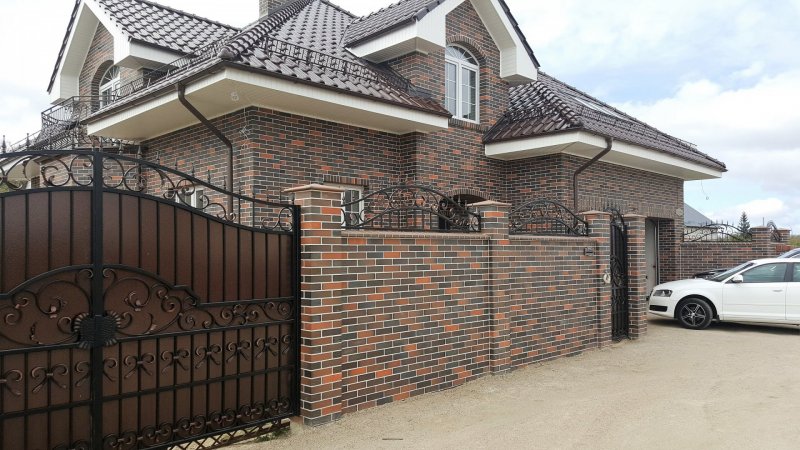Кирпичный дом с забором