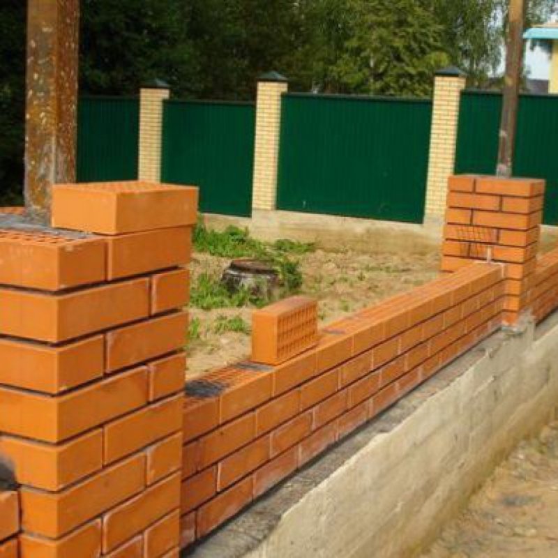 Кирпичная кладка забора с кирпичными столбами