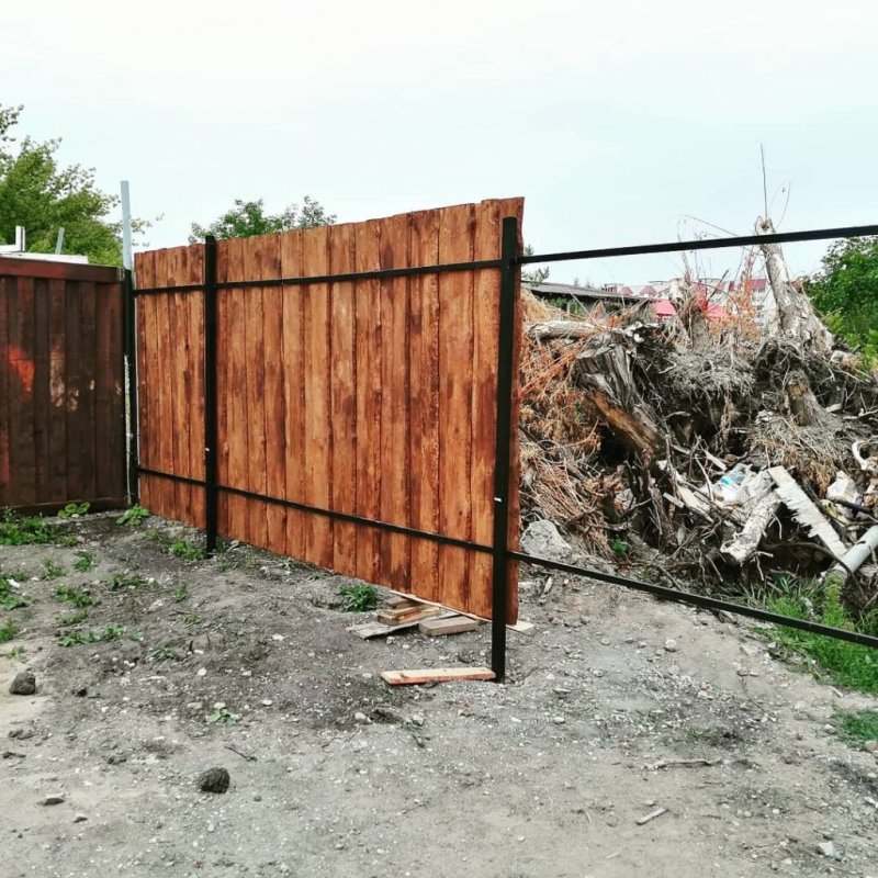 Деревянный забор с каменными столбами