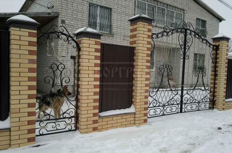 Высокий палисадник с кирпичными столбами