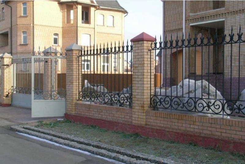 Кованый забор с поликарбонатом и кирпичными столбами