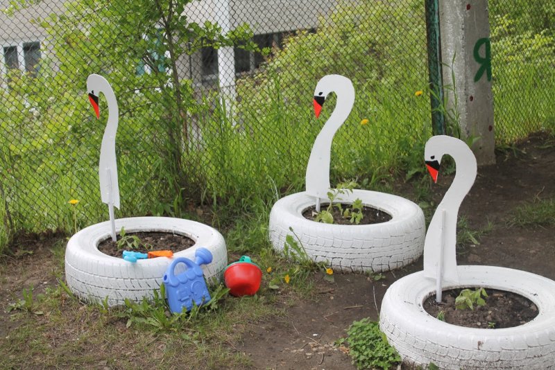 Клумба из бутылок стеклянных с лебедями