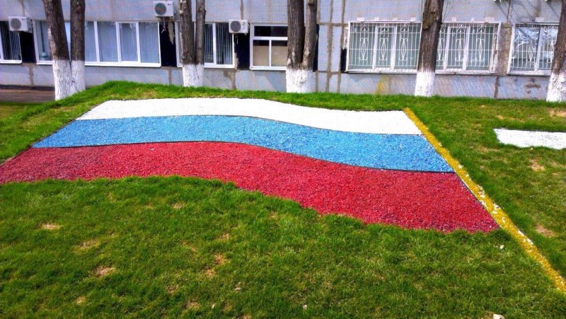 Украшением цветным щебнем в клумбе