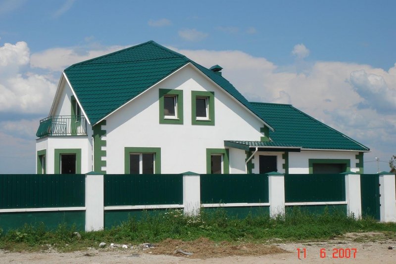 Белый дом с зеленой крышей