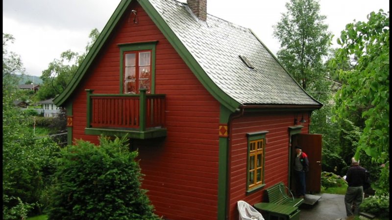 Деревянный дом с зеленой крышей