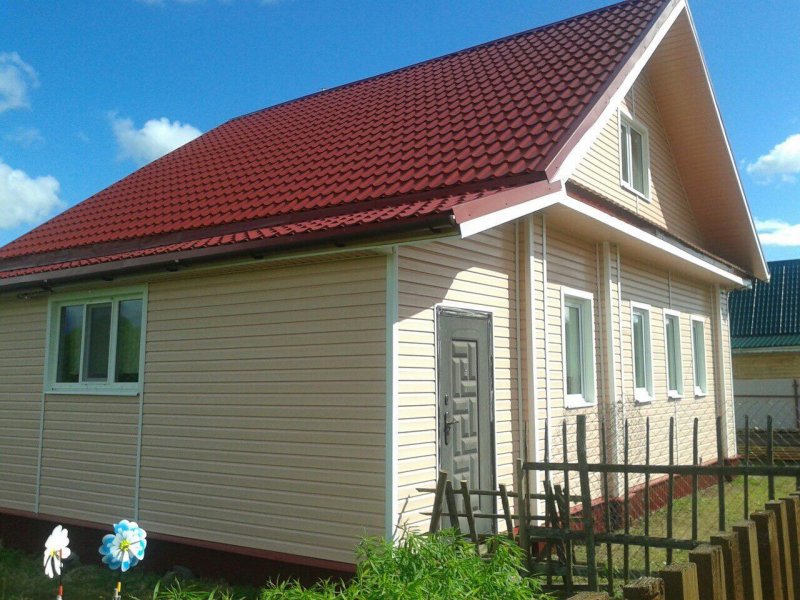 Дом с красной крышей и сайдингом