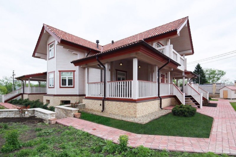 Фасад дома из бруса с красной крышей