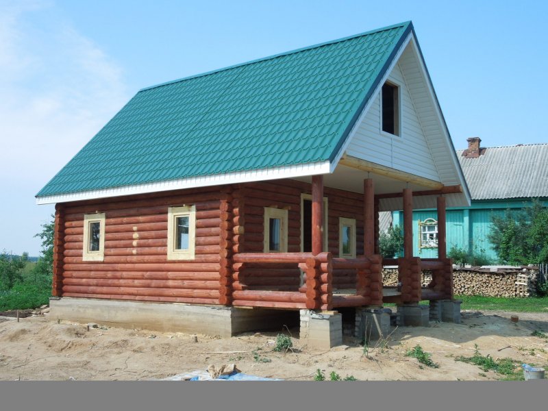 Деревянный дом с зеленой крышей