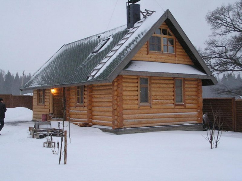 Деревенский домик из бревен зимой