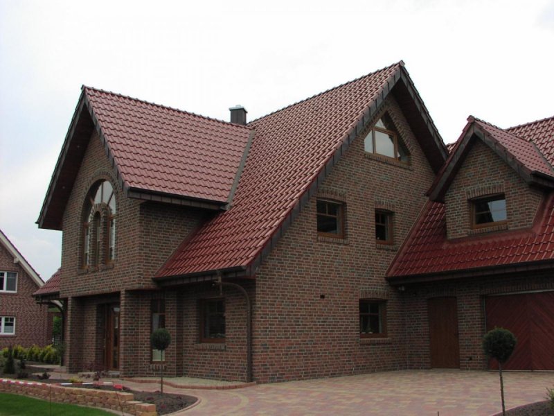 Кирпичный дом с бордовой крышей