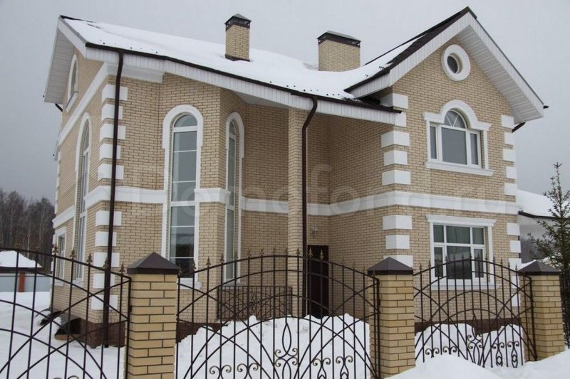Дом из светлого кирпича с белыми окнами