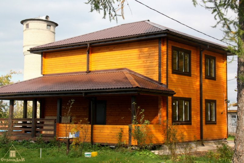 Двухэтажный дом с четырехскатной крышей из бруса