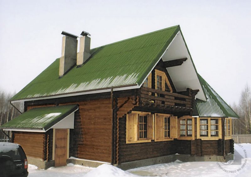 Деревянный дом с зеленой крышей