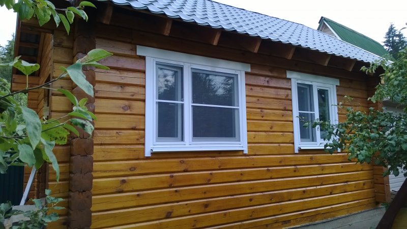 Деревянный дом с пластиковым окном