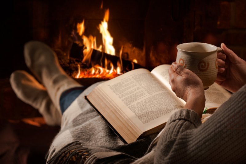 Девушка с книжкой возле камина