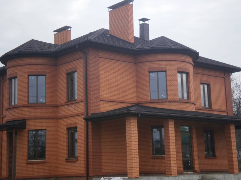 Дом из красного кирпича с коричневыми окнами