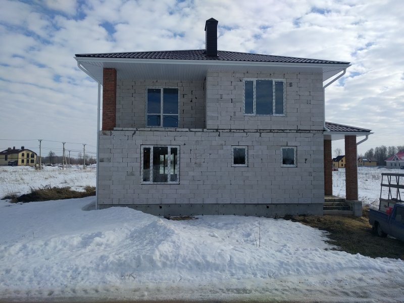 Дом без облицовки в два этажа из газобетона