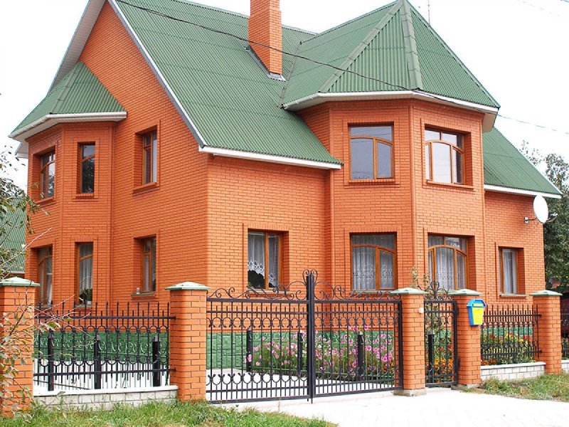 Кирпичный дом с зеленой крышей