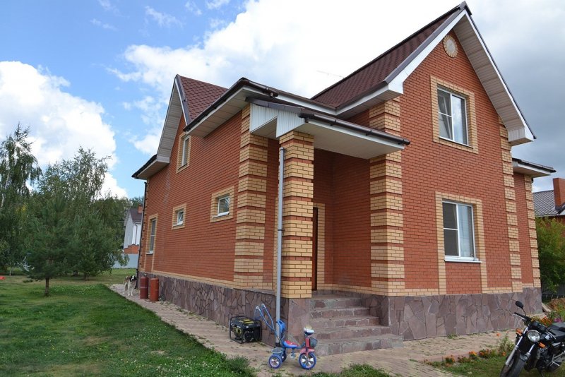Дом из красного кирпича с желтыми углами
