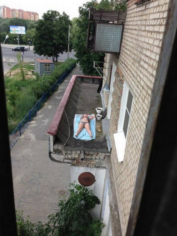 Загорает на балконе