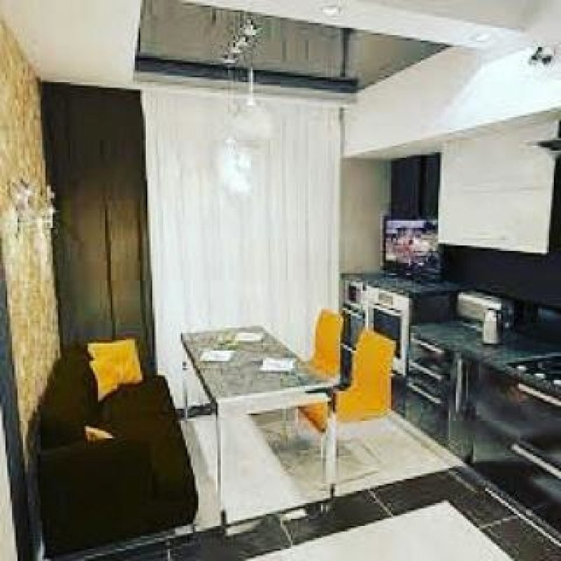 Интерьер кухни с диваном и телевизором