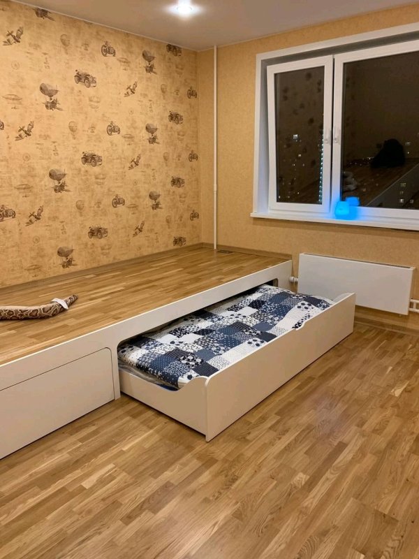 Кровать вдоль окна в спальне