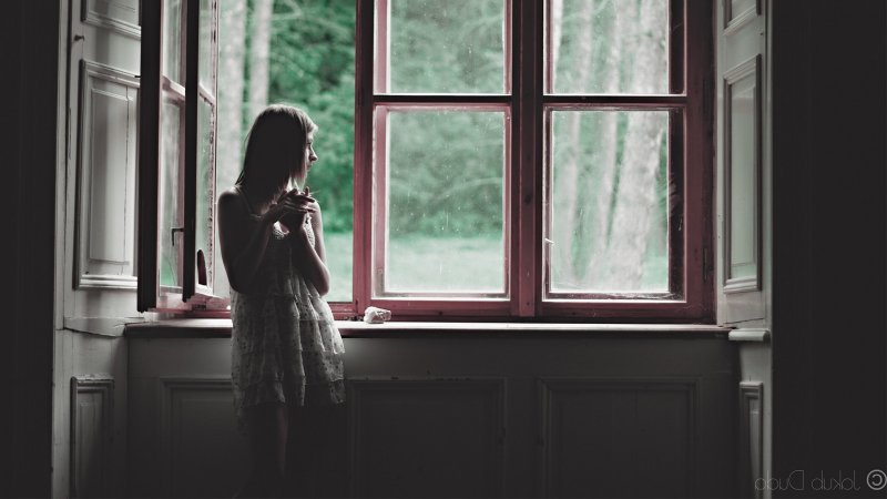 Девочка сидит на подоконнике