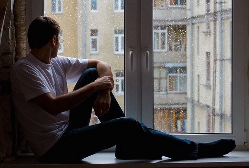 Человек сидит на подоконнике